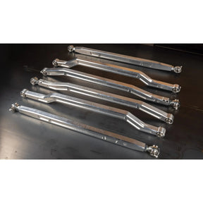 Set of metal control arms on a dark surface